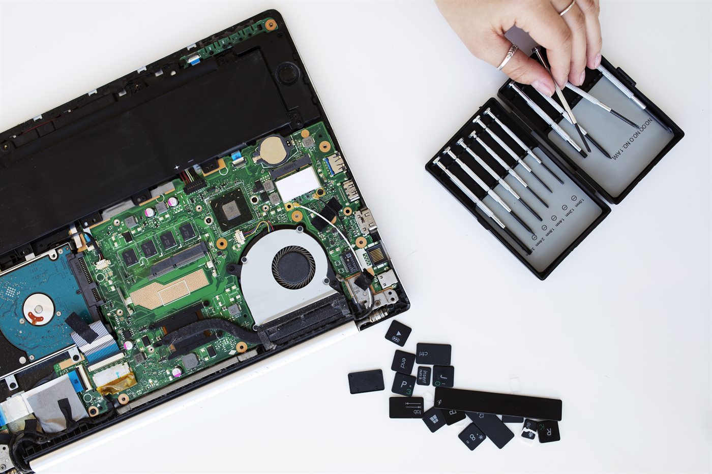 Laptop disassembled for screen repair with screwdriver kit on a bench in Bendigo